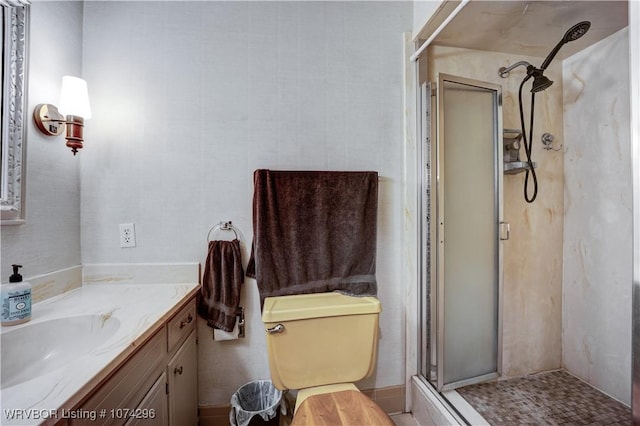 bathroom featuring vanity, a shower with shower door, and toilet