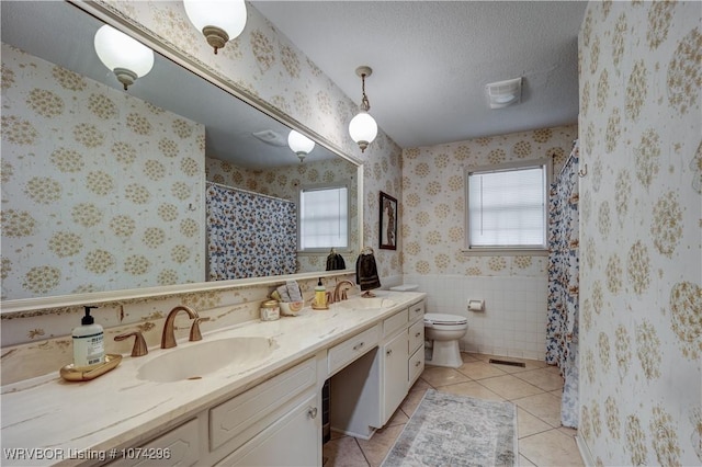 bathroom featuring vanity, a textured ceiling, tile patterned floors, and toilet