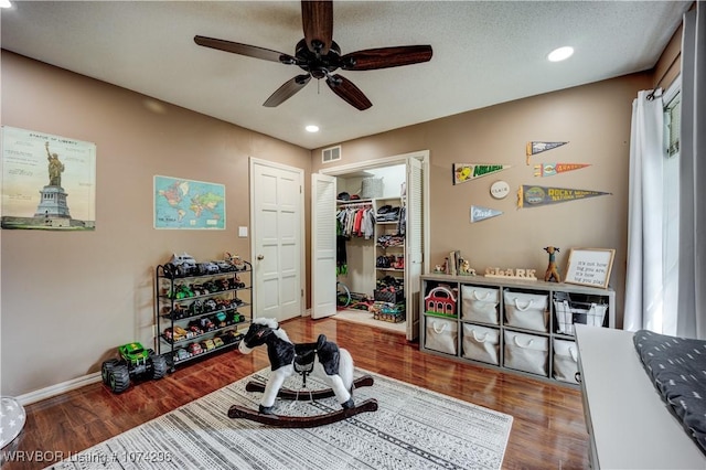 interior space with ceiling fan, a textured ceiling, and hardwood / wood-style flooring