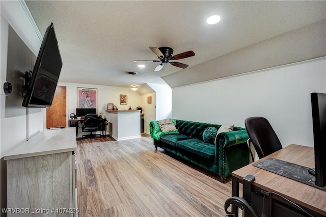 office area featuring a textured ceiling, light hardwood / wood-style flooring, ceiling fan, and lofted ceiling