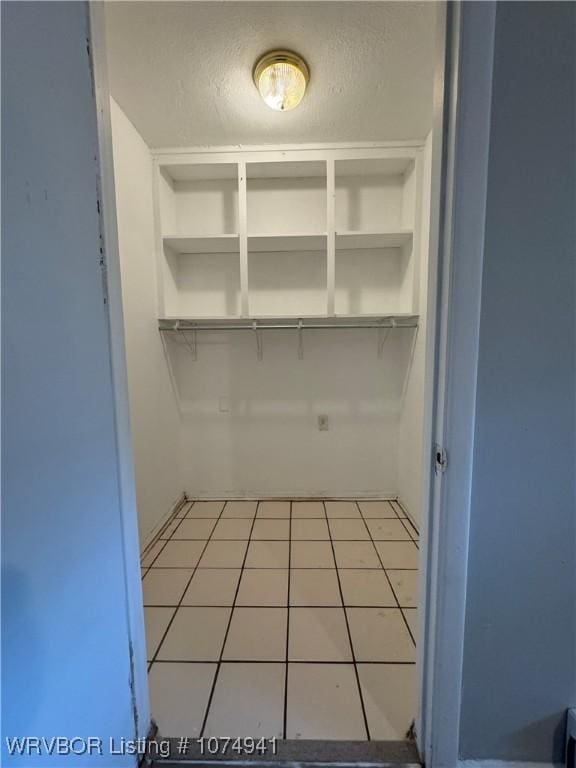 spacious closet with light tile patterned floors