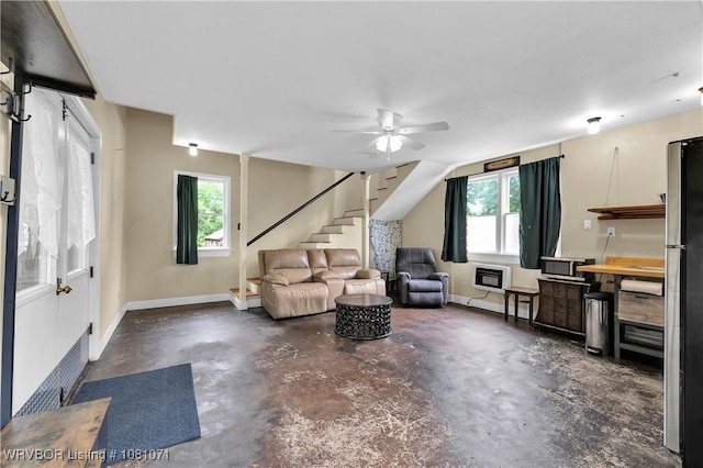 living room with stairs, concrete floors, heating unit, a ceiling fan, and baseboards