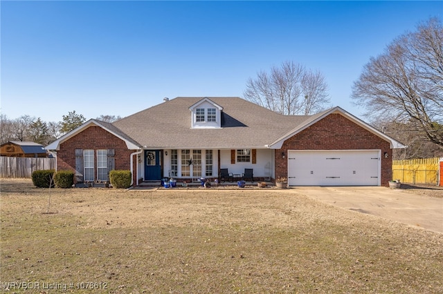 view of front of property with a garage, covered porch, and a front yard