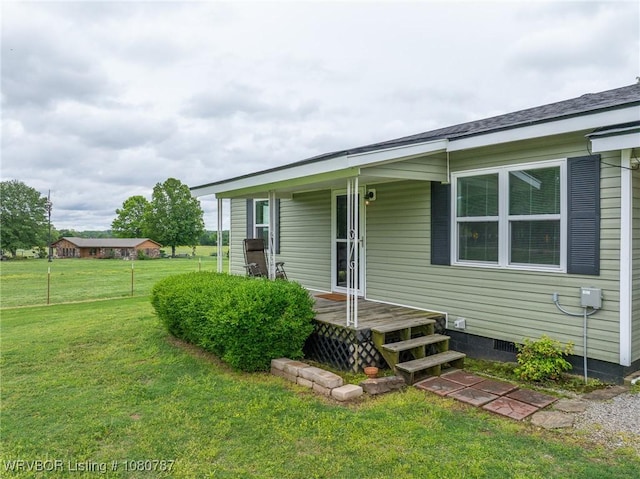 back of house with a lawn and crawl space