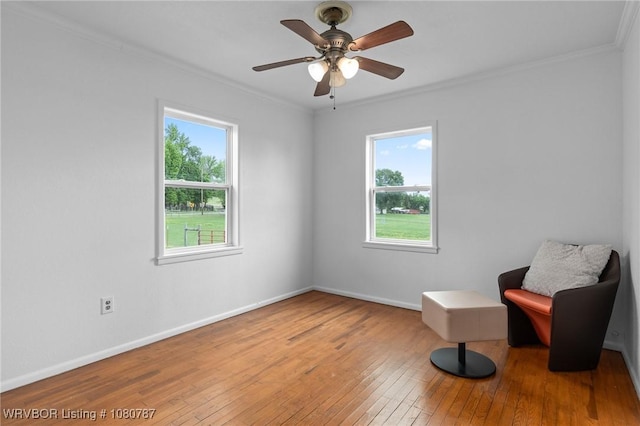 unfurnished room featuring crown molding, hardwood / wood-style flooring, baseboards, and ceiling fan