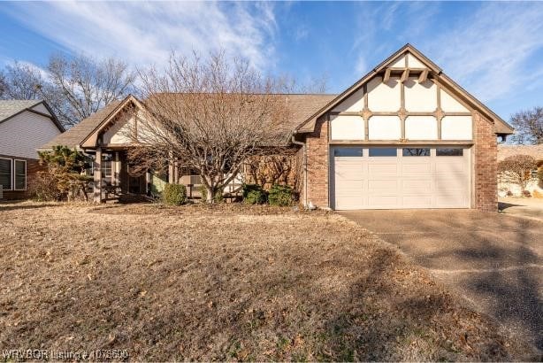 english style home featuring a garage