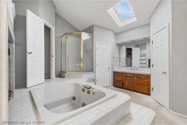 bathroom with vanity, lofted ceiling with skylight, and independent shower and bath