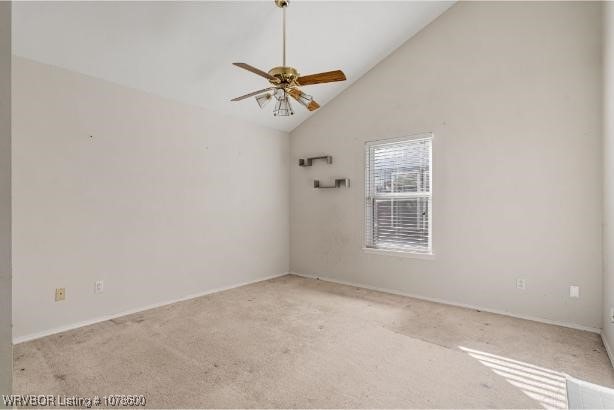 carpeted empty room featuring vaulted ceiling and ceiling fan