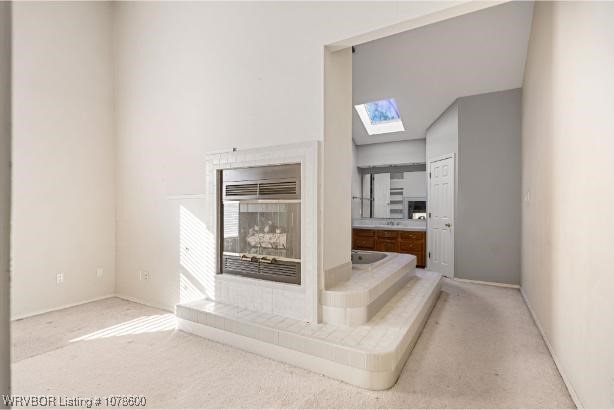 interior space featuring a skylight and light carpet