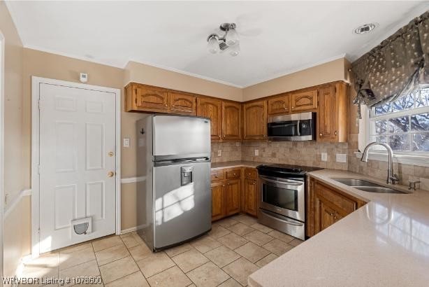 kitchen with stainless steel appliances, sink, light tile patterned floors, and decorative backsplash