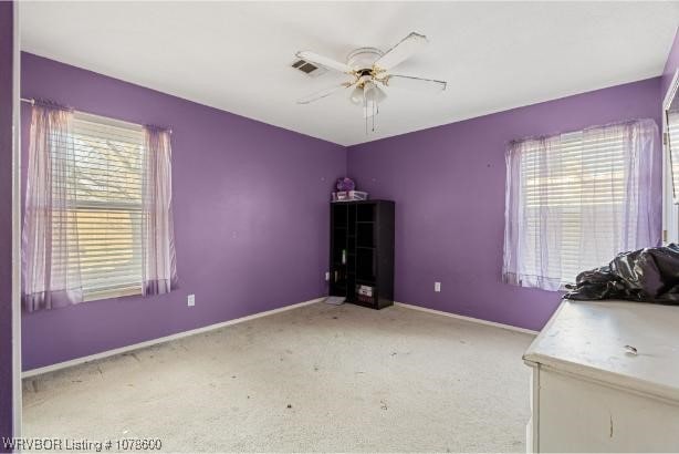 interior space featuring light carpet and ceiling fan