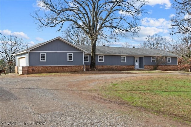 ranch-style home with a garage and a front lawn