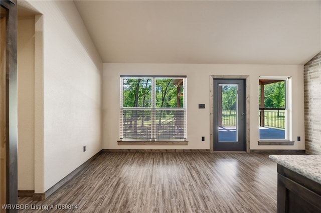 entryway with baseboards, wood finished floors, and vaulted ceiling