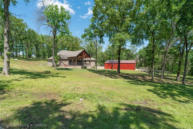 view of yard featuring covered porch and an outbuilding