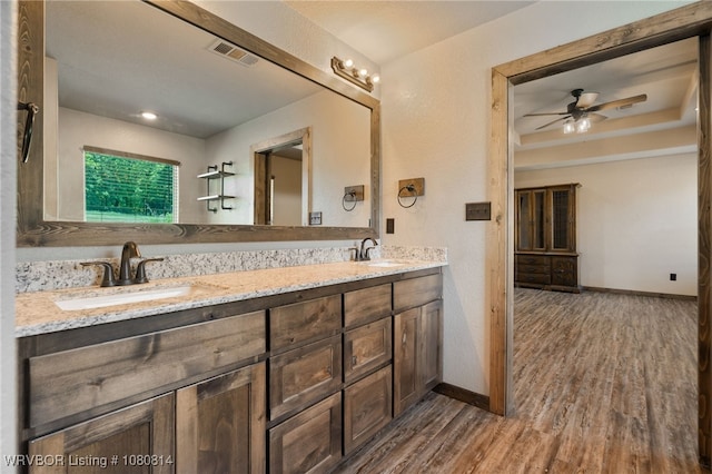 full bathroom with visible vents, a sink, and wood finished floors