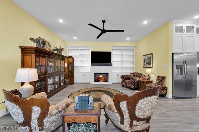 9100 Kirkwood Rd, Fort Smith, AR 72916 - living room featuring a ceiling fan, wood finished floors, a glass covered fireplace, and recessed lighting