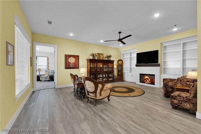 9100 Kirkwood Rd, Fort Smith, AR 72916 - living room with wood finished floors, ceiling fan, a glass covered fireplace, and recessed lighting