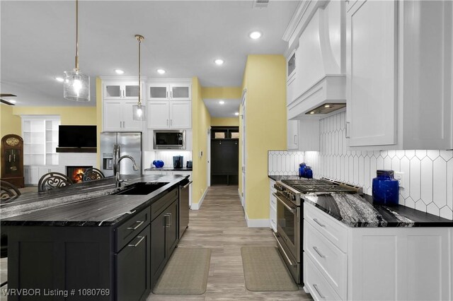 9100 Kirkwood Rd, Fort Smith, AR 72916 - kitchen with stainless steel appliances, premium range hood, decorative backsplash, white cabinetry, and light wood-type flooring