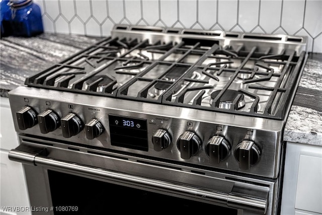 9100 Kirkwood Rd, Fort Smith, AR 72916 - details with stainless steel gas range, decorative backsplash, and light stone counters