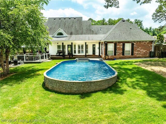 back of house featuring an outdoor pool, roof with shingles, and a deck