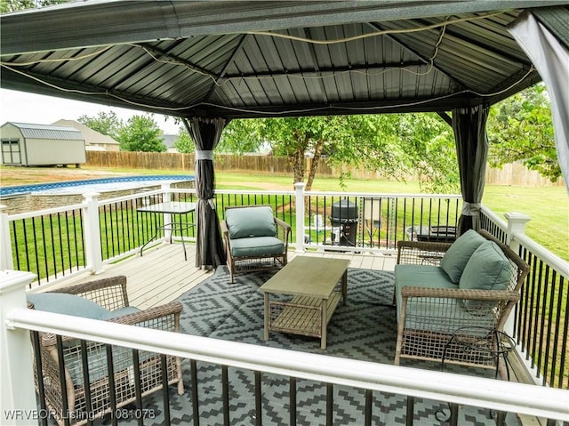 deck with a gazebo, an outdoor hangout area, a shed, and an outdoor structure