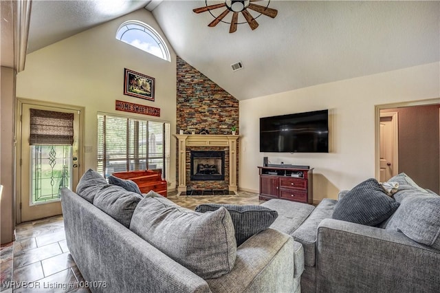 living room featuring a ceiling fan, high vaulted ceiling, and a fireplace