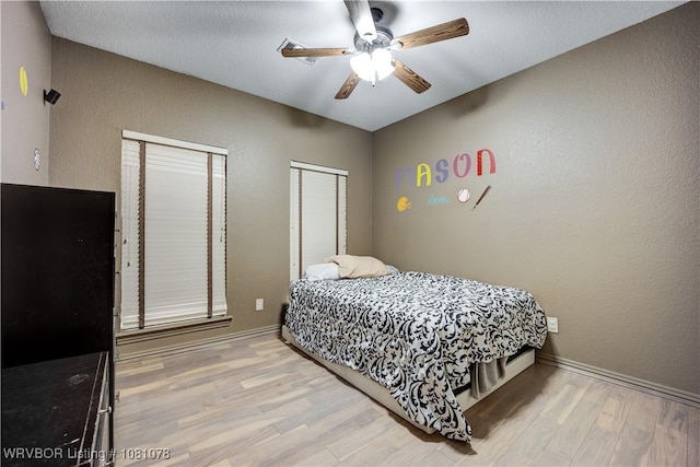 bedroom featuring wood finished floors, baseboards, and ceiling fan