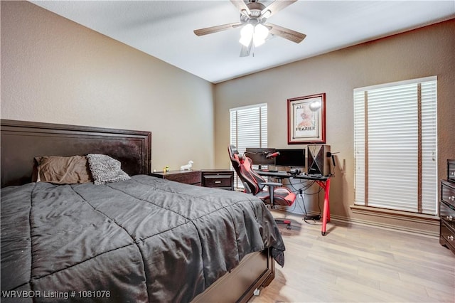 bedroom featuring wood finished floors, baseboards, and a ceiling fan