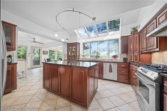 10301 Stoneleige St, Fort Smith, AR 72908 - kitchen featuring appliances with stainless steel finishes, a center island, decorative backsplash, light tile patterned floors, and glass insert cabinets