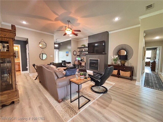 2420 Keystone Cir, Mulberry, AR 73947 - living room with a fireplace, light wood finished floors, plenty of natural light, ornamental molding, and recessed lighting