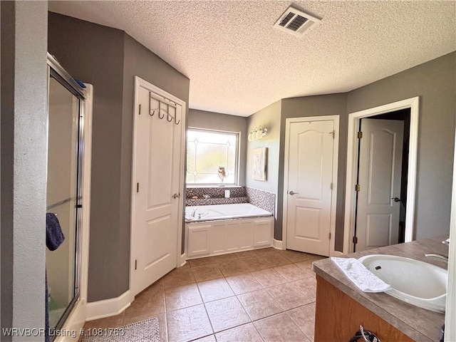 2420 Keystone Cir, Mulberry, AR 73947 - bathroom featuring a stall shower, a garden tub, tile patterned flooring, a textured ceiling, and vanity