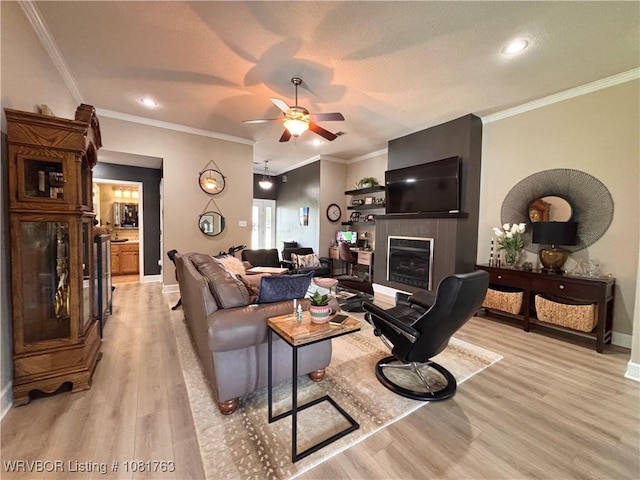 2420 Keystone Cir, Mulberry, AR 73947 - living area with light wood-type flooring, ceiling fan, a glass covered fireplace, ornamental molding, and recessed lighting