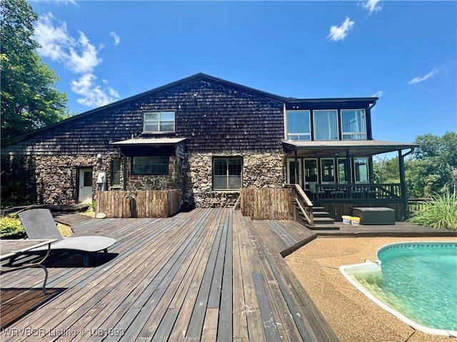 4018 Blue Hole Rd, Rudy, AR 72952 - back of property with a wooden deck, stone siding, and an outdoor pool