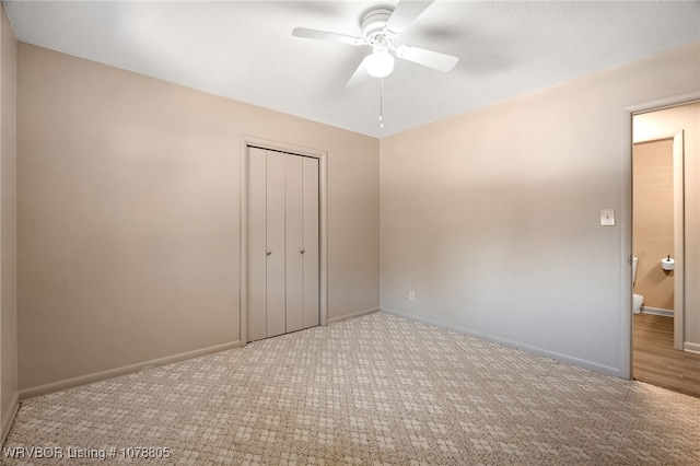 unfurnished bedroom featuring ceiling fan, a closet, and light carpet