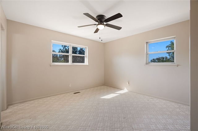 carpeted spare room featuring ceiling fan