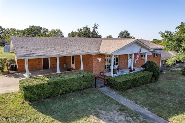 ranch-style home featuring a porch and a front lawn