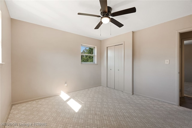 unfurnished bedroom with ceiling fan, light carpet, and a closet