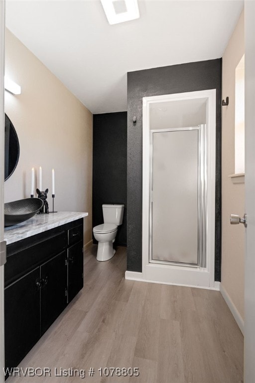 bathroom with hardwood / wood-style flooring, vanity, toilet, and an enclosed shower