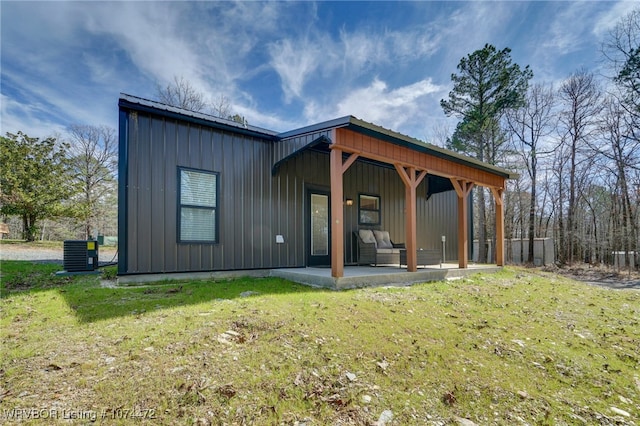 rear view of property featuring a yard, central AC, and a patio area