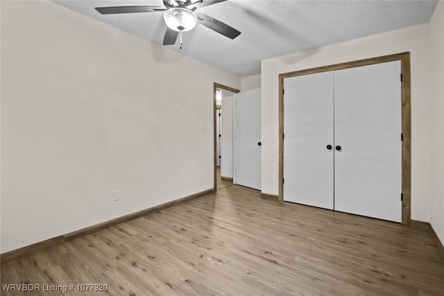 unfurnished bedroom with ceiling fan, a closet, a textured ceiling, and light hardwood / wood-style flooring