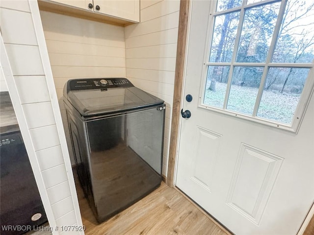 laundry room featuring washer / clothes dryer, cabinets, and light wood-type flooring