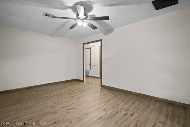 spare room with ceiling fan, a textured ceiling, and light wood-type flooring