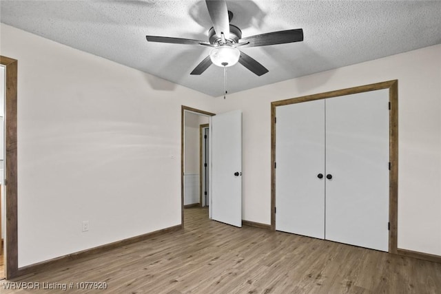 unfurnished bedroom featuring ceiling fan, a closet, light hardwood / wood-style floors, and a textured ceiling