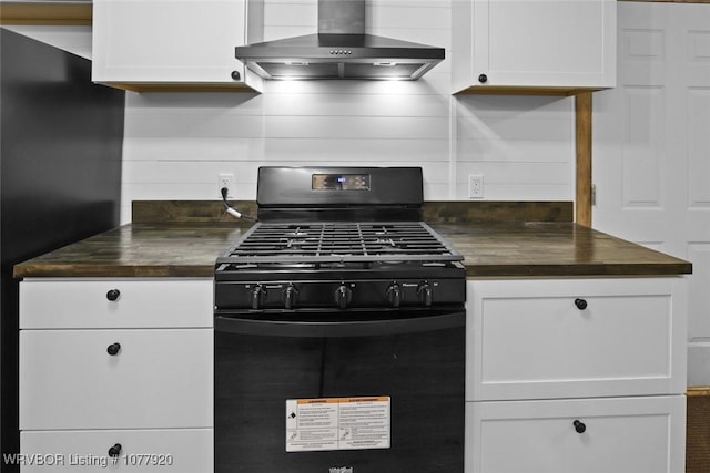 kitchen with gas stove, white cabinetry, and wall chimney exhaust hood