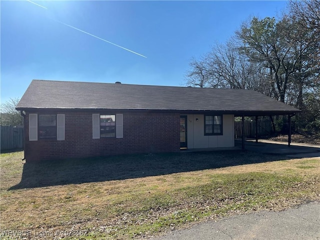 single story home with a front yard and a carport