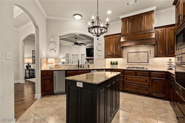 8404 Gatehouse Way, Fort Smith, AR 72916 - kitchen featuring arched walkways, a ceiling fan, crown molding, a kitchen island, and tasteful backsplash
