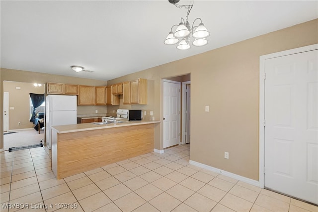 kitchen featuring light tile patterned floors, light brown cabinets, a peninsula, light countertops, and decorative light fixtures