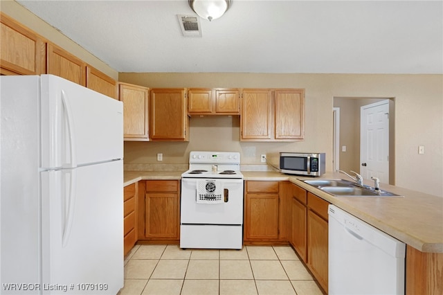 kitchen featuring light countertops, white appliances, a sink, and visible vents