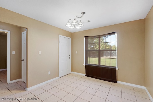 empty room featuring visible vents, a notable chandelier, baseboards, and light tile patterned floors