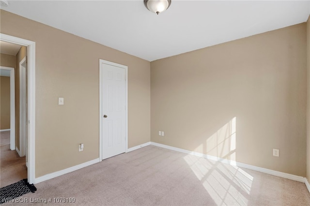 unfurnished bedroom with light carpet and baseboards